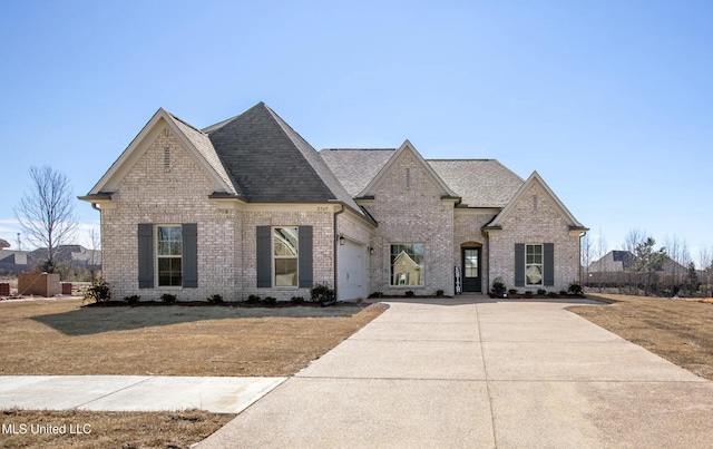 1716 Ryker Rd, Southaven, MS 38672 - french country home with brick siding, a garage, concrete driveway, and a shingled roof