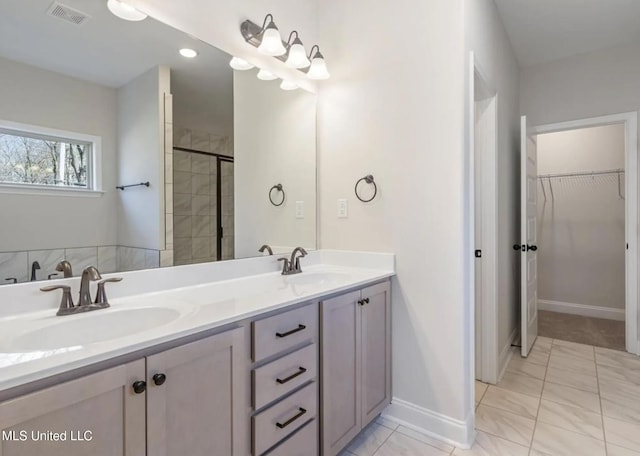 1716 Ryker Rd, Southaven, MS 38672 - bathroom featuring double vanity, a walk in closet, and tiled shower