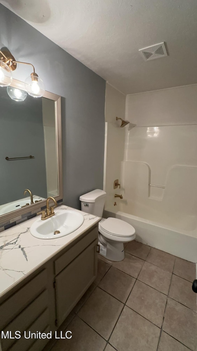 full bathroom with shower / washtub combination, tile patterned flooring, vanity, toilet, and a textured ceiling