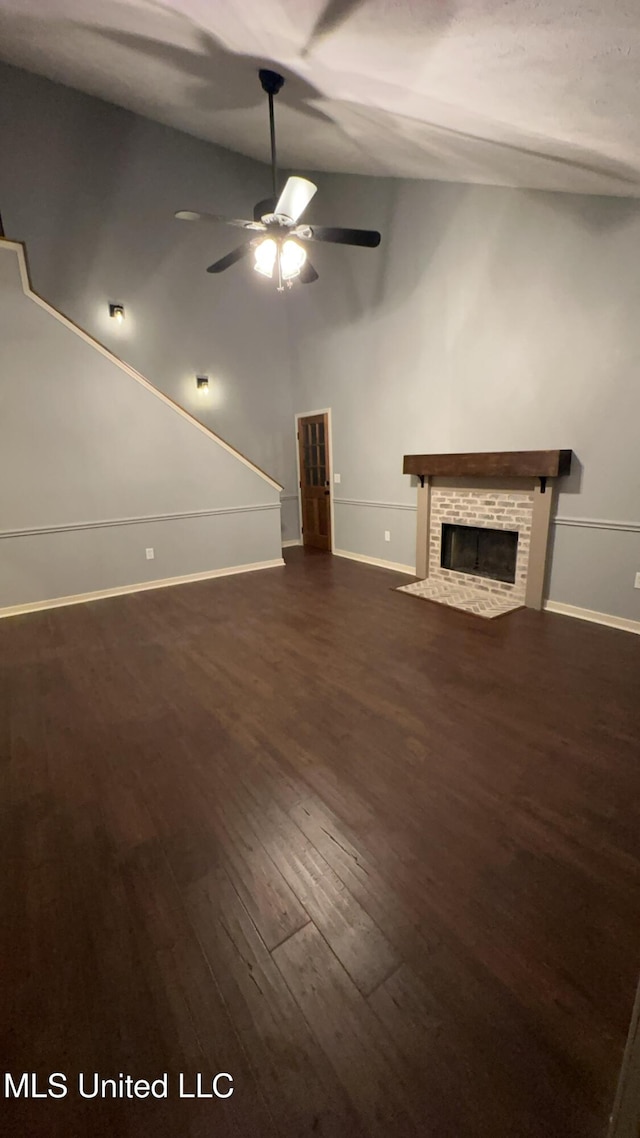 unfurnished living room featuring lofted ceiling, dark hardwood / wood-style floors, and ceiling fan