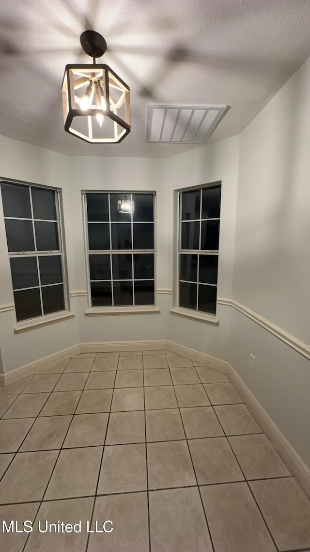 tiled spare room with a textured ceiling