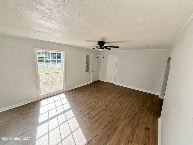 empty room with a textured ceiling, dark wood-type flooring, and ceiling fan