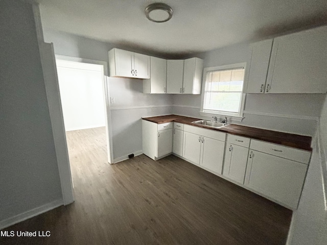 2123 Belvedere Dr, Jackson, MS 39204 - kitchen with a sink, dark wood-type flooring, wood counters, white cabinetry, and baseboards