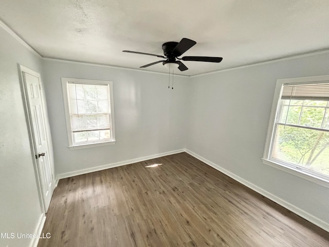 spare room featuring ornamental molding, ceiling fan, hardwood / wood-style flooring, and plenty of natural light