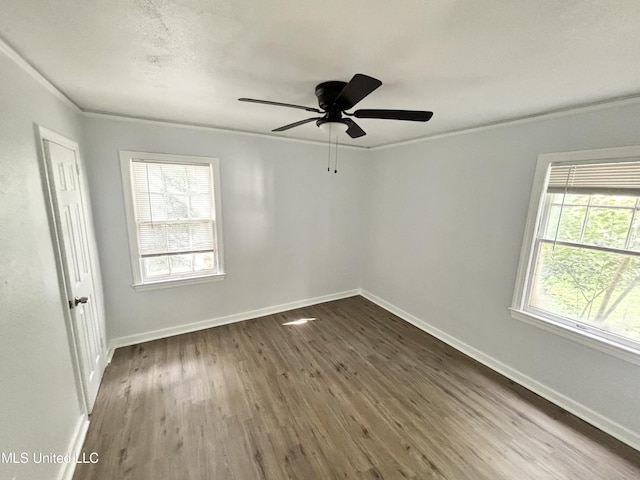 2123 Belvedere Dr, Jackson, MS 39204 - spare room featuring dark wood-type flooring, healthy amount of natural light, baseboards, a ceiling fan, and ornamental molding