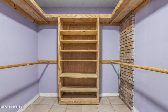 walk in closet with light tile patterned floors