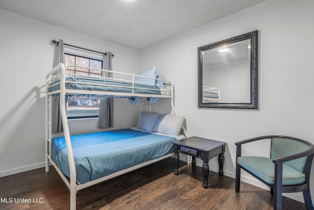 bedroom featuring a textured ceiling and dark wood-type flooring