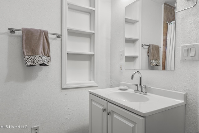 bathroom featuring vanity and curtained shower