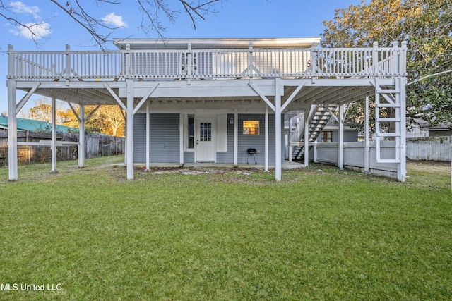 rear view of property with a yard and a wooden deck