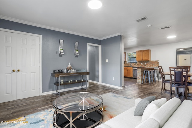 living room featuring crown molding, dark wood-type flooring, and sink