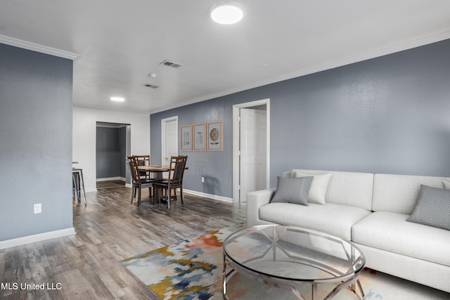 living room with wood-type flooring and ornamental molding