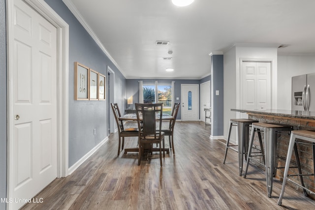 dining area featuring crown molding and dark wood-type flooring