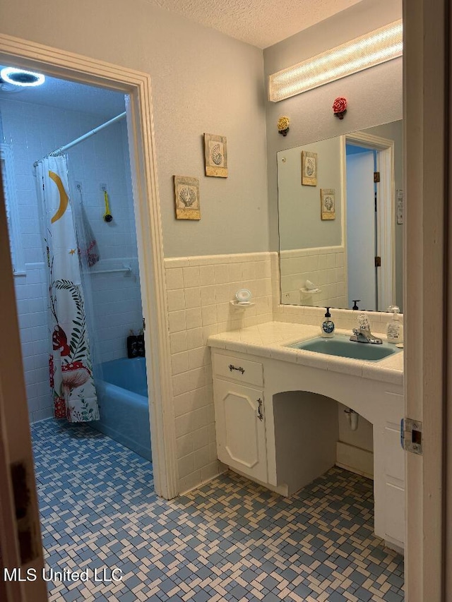 1173 NW Ave, Durant, MS 39063 - bathroom with tile walls, a textured ceiling, a wainscoted wall, shower / bath combination with curtain, and vanity