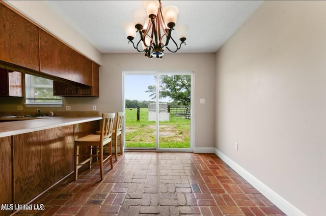 4127 Ceolia Taylor Rd, Moss Point, MS 39562 - kitchen featuring a chandelier, healthy amount of natural light, baseboards, and light countertops
