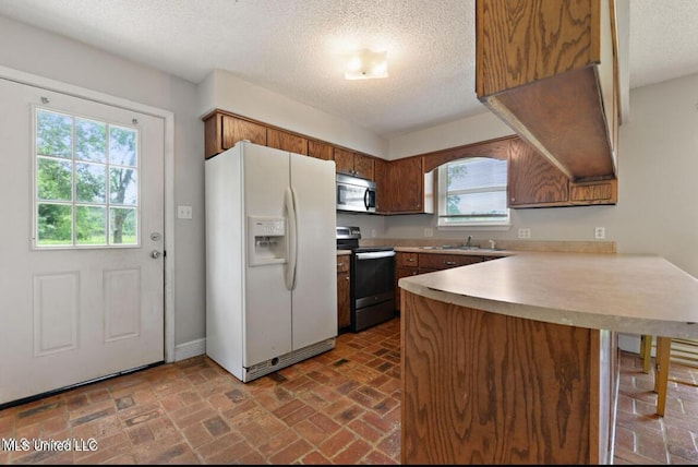 4127 Ceolia Taylor Rd, Moss Point, MS 39562 - kitchen with stainless steel appliances, a peninsula, a sink, a textured ceiling, and light countertops