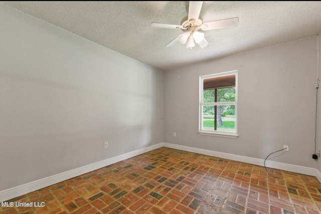 4127 Ceolia Taylor Rd, Moss Point, MS 39562 - spare room with a textured ceiling, brick floors, baseboards, and ceiling fan