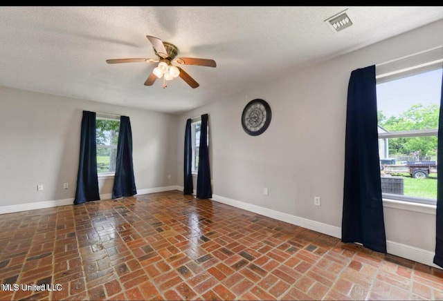 4127 Ceolia Taylor Rd, Moss Point, MS 39562 - unfurnished room with a ceiling fan, baseboards, brick flooring, and a textured ceiling