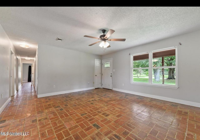 4127 Ceolia Taylor Rd, Moss Point, MS 39562 - empty room with brick floors, a ceiling fan, baseboards, and a textured ceiling