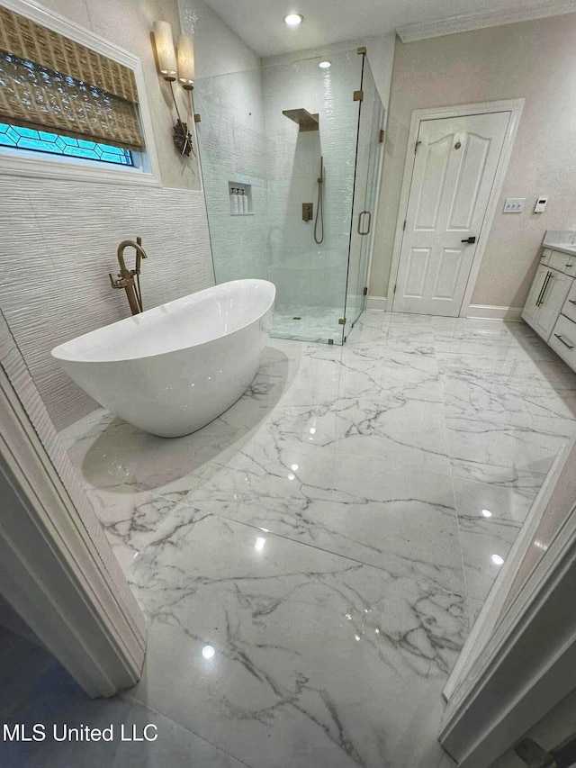 bathroom featuring a stall shower, a freestanding tub, vanity, marble finish floor, and baseboards