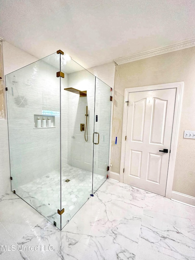 full bath with marble finish floor, baseboards, ornamental molding, and a stall shower