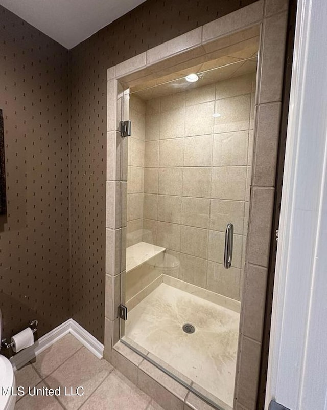 full bathroom featuring a shower stall, tile patterned flooring, and toilet