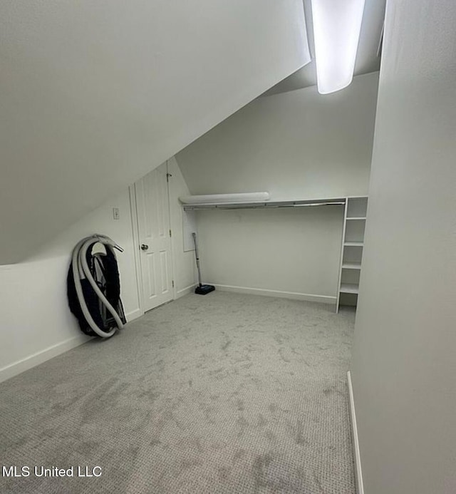 bonus room with vaulted ceiling, baseboards, and carpet