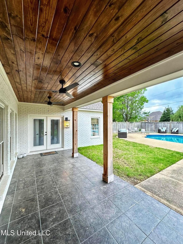 view of patio / terrace featuring ceiling fan, a fenced backyard, a fenced in pool, and french doors