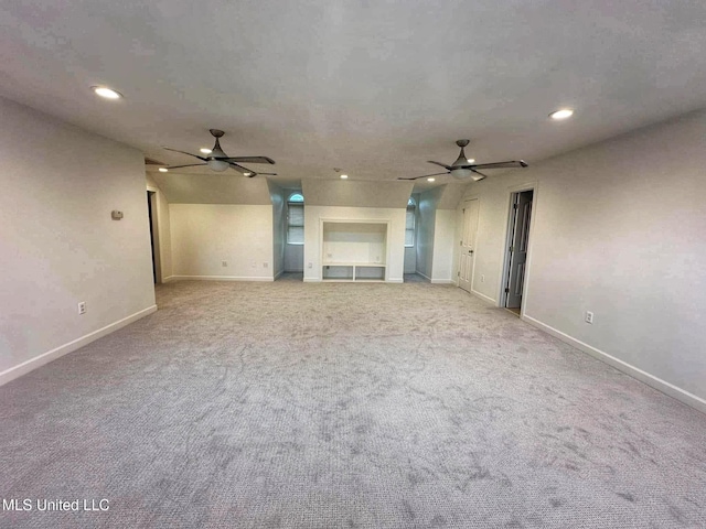 unfurnished living room with carpet flooring, a ceiling fan, and baseboards