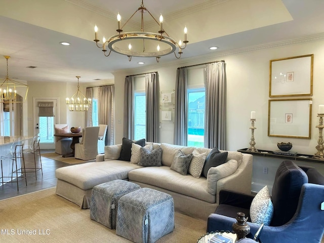 living area featuring a healthy amount of sunlight, crown molding, and an inviting chandelier