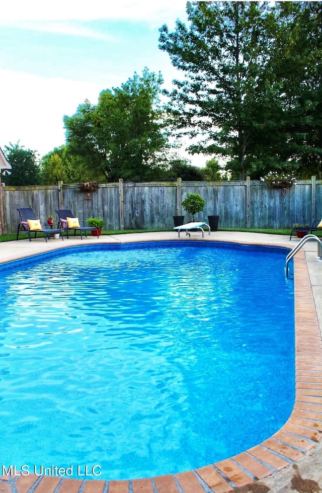 view of swimming pool with a fenced backyard, a fenced in pool, and a diving board