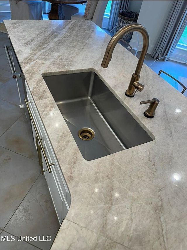 details featuring light stone counters and a sink