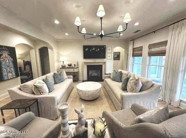 living room with arched walkways, baseboards, a notable chandelier, visible vents, and recessed lighting