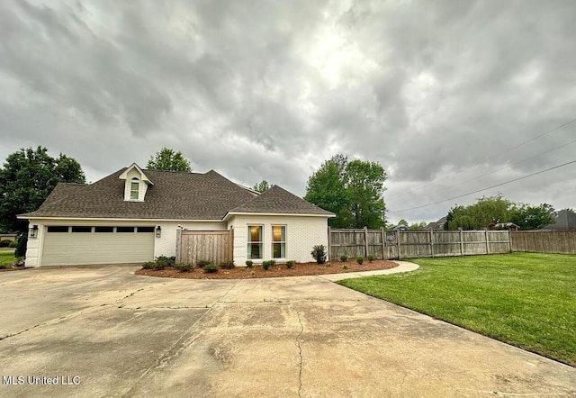view of front of property featuring concrete driveway, fence, a garage, a shingled roof, and a front yard