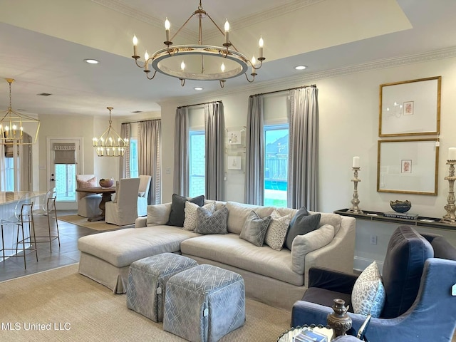 living area featuring an inviting chandelier, ornamental molding, and a healthy amount of sunlight