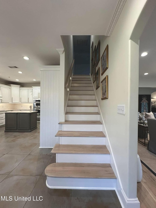 stairway with baseboards, visible vents, and recessed lighting