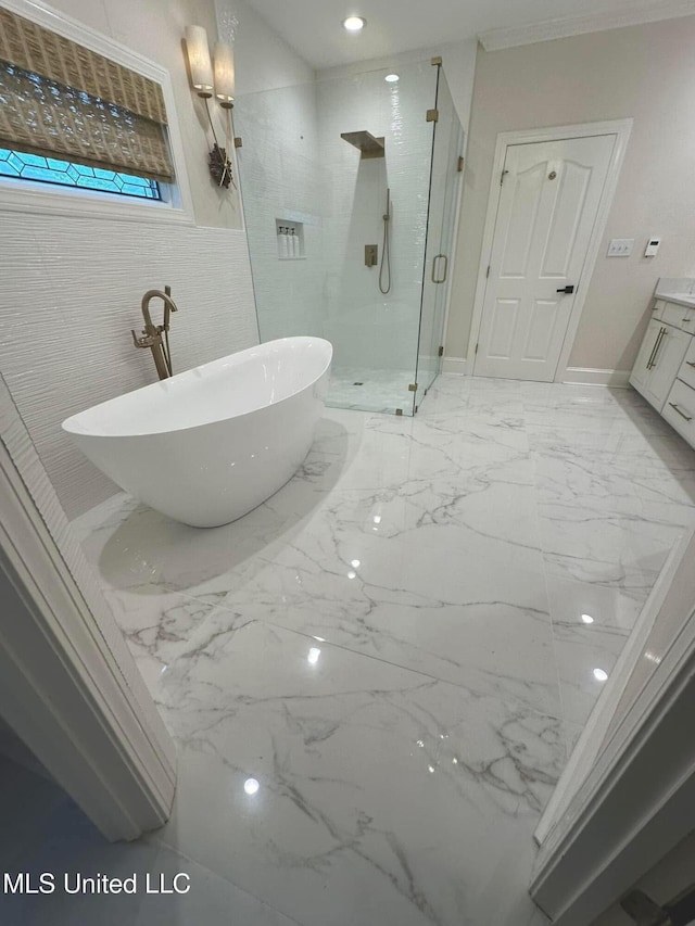 full bathroom featuring a shower stall, marble finish floor, a freestanding tub, and vanity