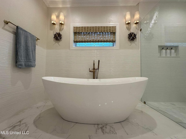 bathroom featuring tile walls, a soaking tub, marble finish floor, and crown molding