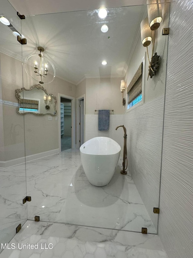bathroom with a freestanding bath, crown molding, and marble finish floor