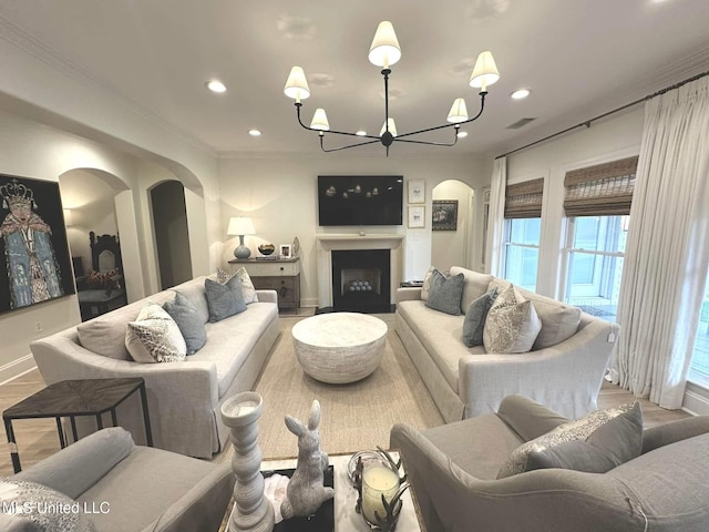 living area featuring recessed lighting, arched walkways, a chandelier, and baseboards