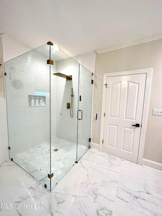 bathroom with a shower stall, marble finish floor, baseboards, and ornamental molding