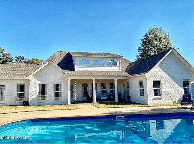 back of house featuring an outdoor pool and a patio