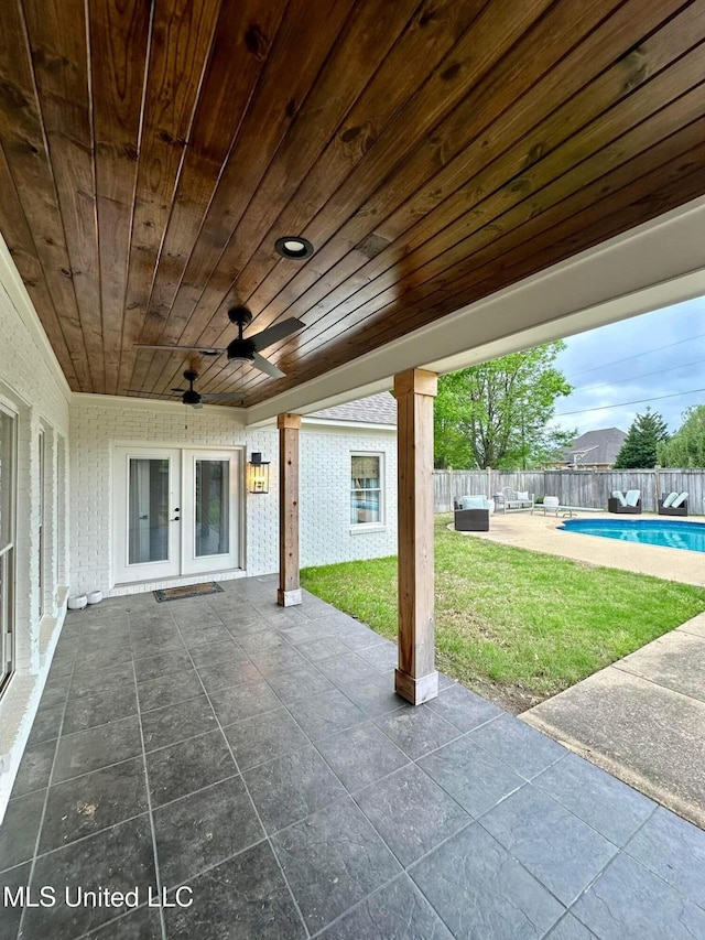 view of patio / terrace with french doors, a fenced in pool, a fenced backyard, and ceiling fan