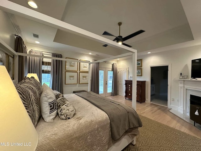 bedroom with light wood-style flooring, access to exterior, multiple windows, and visible vents