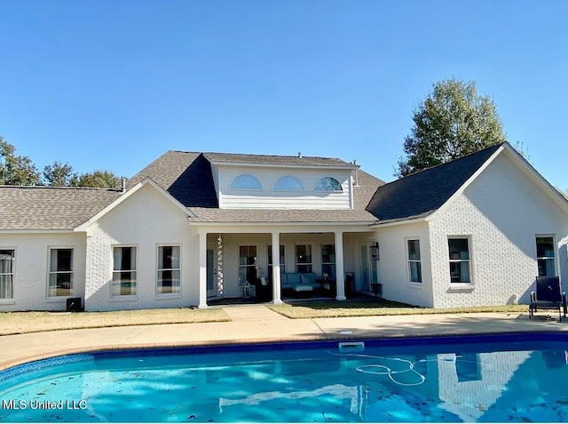 rear view of house with a patio area and an outdoor pool