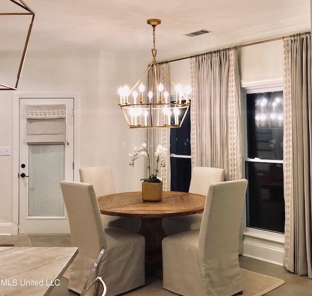 dining area featuring visible vents, crown molding, and a notable chandelier