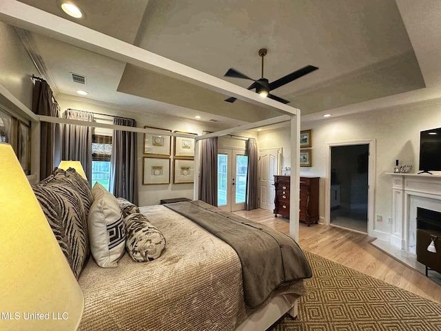 bedroom with wood finished floors, access to exterior, multiple windows, and visible vents