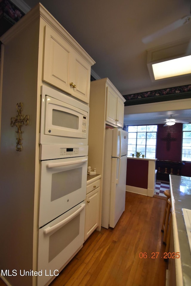1211 River Rd, Greenwood, MS 38930 - kitchen with white appliances, wood finished floors, and white cabinetry