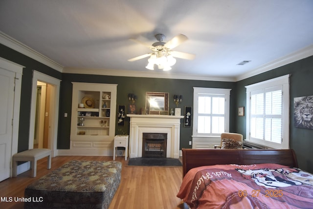 1211 River Rd, Greenwood, MS 38930 - bedroom with a fireplace with raised hearth, wood finished floors, ornamental molding, and ceiling fan