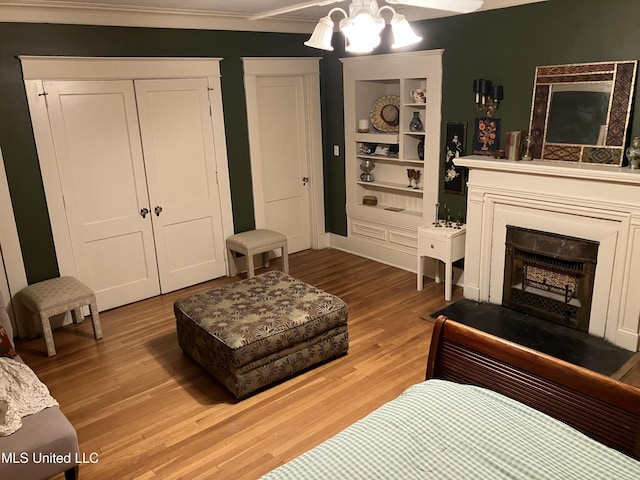 1211 River Rd, Greenwood, MS 38930 - living room with wood finished floors, a fireplace, built in features, a chandelier, and ornamental molding