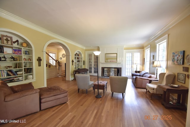 1211 River Rd, Greenwood, MS 38930 - living area featuring wood finished floors, a brick fireplace, crown molding, arched walkways, and built in features